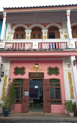 a pink and white building with a balcony at 2ROOMS Boutique House in Phuket Town
