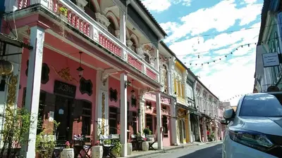 a street with a car parked in front of a building at 2ROOMS Boutique House in Phuket Town