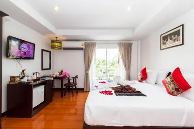 a bedroom with a bed and a desk and a television at Silver Resortel in Patong Beach