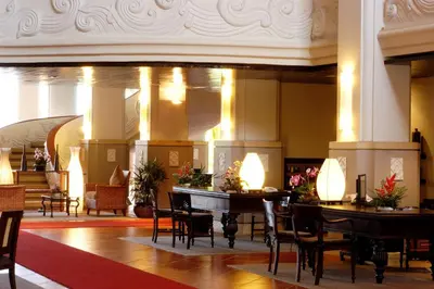 a lobby with tables and chairs in a building at Mission Hills Phuket Golf Resort-SHA Extra Plus in Por Bay