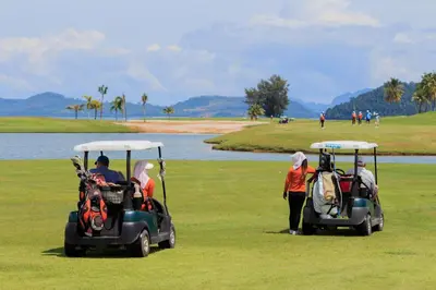 a group of people riding golf carts on a golf course at Mission Hills Phuket Golf Resort-SHA Extra Plus in Por Bay
