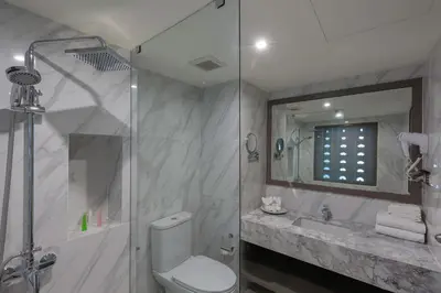 a bathroom with a toilet and a sink and a shower at Chanalai Flora Resort, Kata Beach in Kata Beach