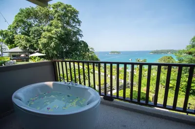 a bath tub on a balcony with a view of the ocean at Andaman Cannacia Resort & Spa - SHA Extra Plus in Kata Beach
