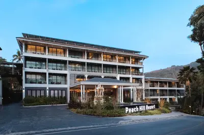 a large building with a sign in front of it at Peach Hill Resort - SHA Extra Plus in Kata Beach