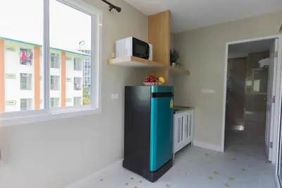 a kitchen with a black refrigerator and a window at The Royal P Phuket - SHA Plus in Phuket Town
