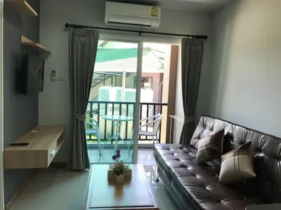 a living room with a couch and a balcony at The Sea Condo Cozy Private Room at Ao nang Krabi in Ao Nang Beach