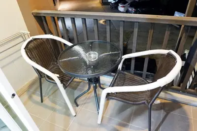 a glass table and two chairs on a balcony at The Sea Condo Cozy Private Room at Ao nang Krabi in Ao Nang Beach