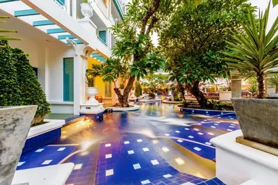 a lobby of a resort with palm trees and a pool at Andaman Seaview, Karon Beach - SHA Plus in Karon Beach