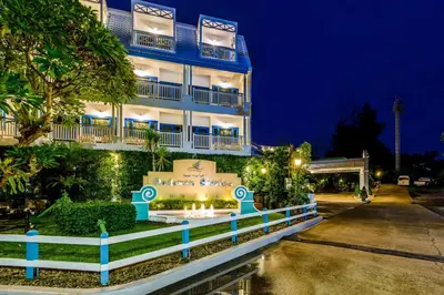 a blue building with a white fence in front of it at Andaman Seaview, Karon Beach - SHA Plus in Karon Beach