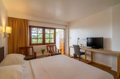 a hotel room with a bed and a desk with a television at Best Western Phuket Ocean Resort in Karon Beach