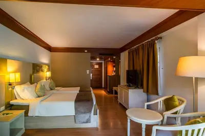 a hotel room with a bed and a table and chairs at Best Western Premier Bangtao Beach Resort & Spa in Bang Tao Beach