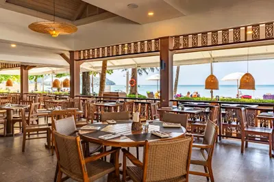 a restaurant with tables and chairs and a view of the ocean at Best Western Premier Bangtao Beach Resort & Spa in Bang Tao Beach