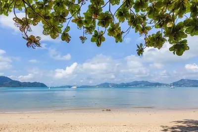 a view of a beach with mountains in the background at By The Sea in Panwa Beach