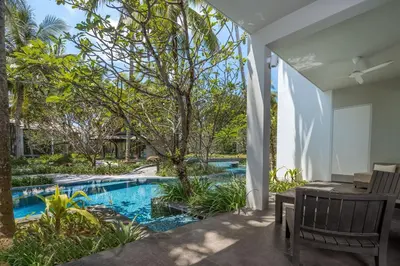 a pool with a table and chairs next to a house at Twinpalms Surin Beach Phuket in Surin Beach