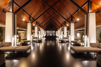 a lobby with couches and tables and a wooden ceiling at Twinpalms Surin Beach Phuket in Surin Beach