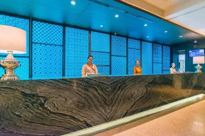 three people sitting at a long counter in a room at The Royal Paradise Hotel & Spa in Patong Beach