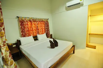 a bedroom with a white bed with shoes on it at Phi Phi Twin Palms Bungalow in Phi Phi Don