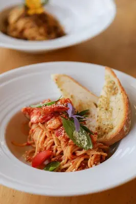 a bowl of spaghetti with a slice of bread at The Golddiggers Resort in Nai Yang Beach