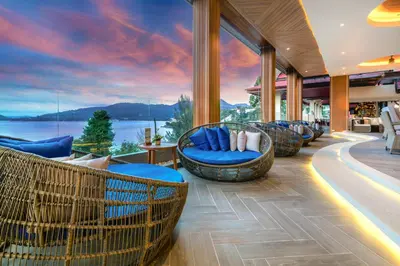 a resort lobby with chairs and a view of the water at Namaka Resort Kamala in Kamala Beach