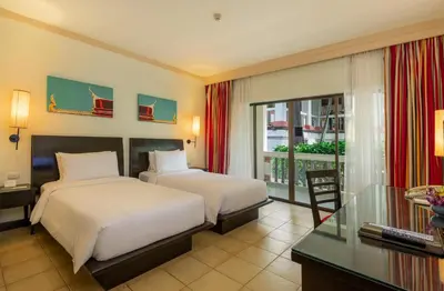 a hotel room with two beds and a balcony at Centara Kata Resort Phuket in Kata Beach