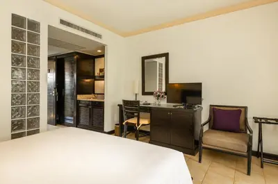 a bedroom with a bed and a desk and a chair at Centara Kata Resort Phuket in Kata Beach
