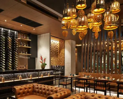 a restaurant with tables and chairs and chandeliers at Holiday Inn Resort Krabi Ao Nang Beach by IHG in Ao Nang Beach