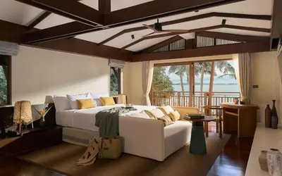 a bedroom with a white bed and a couch at Barcelo Coconut Island, Phuket in Phuket Town