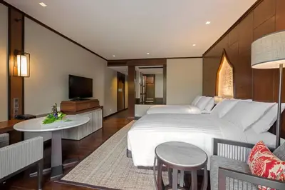 a bedroom with a large bed and a living room at Phuket Marriott Resort and Spa, Nai Yang Beach in Nai Yang Beach