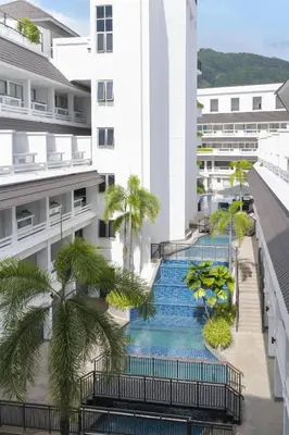 an external view of a building with stairs and palm trees at Radisson RED Phuket Patong Beach in Patong Beach