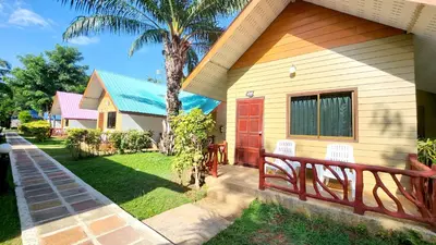 a house with a porch with two chairs and a tree at Mild Garden View Resort in Ao Nang Beach