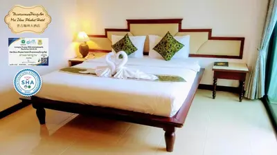a bedroom with a bed with two swans on it at Mei Zhou Phuket Hotel - SHA Plus in Phuket Town