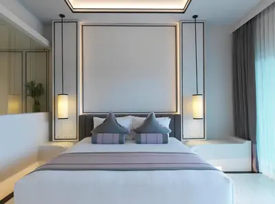 a bedroom with a large white bed with two pillows at Chanalai Romantica Resort - Adults Only, Kata Beach in Kata Beach