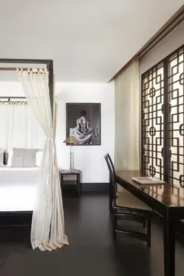 a dining room with a table and a bed at The Pavilions Phuket in Bang Tao Beach