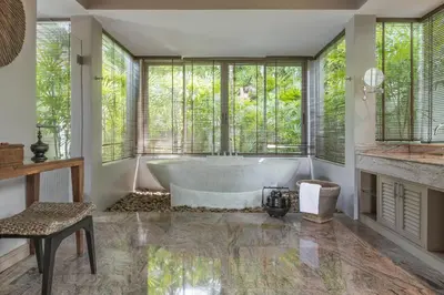 a bathroom with a tub in a room with windows at The Pavilions Phuket in Bang Tao Beach