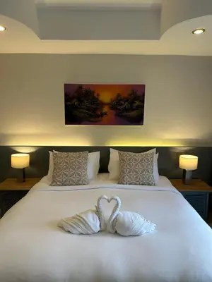 two white swans sitting on top of a bed at Sea Hills Resort in Patong Beach