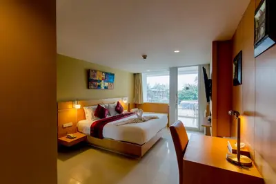 a hotel room with a bed and a window at Aspery Hotel in Patong Beach