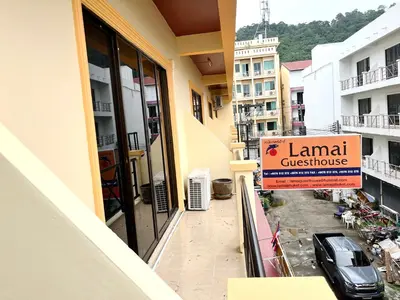 a sign on a balcony of a building with a car at Patong Lamai Residence in Patong Beach
