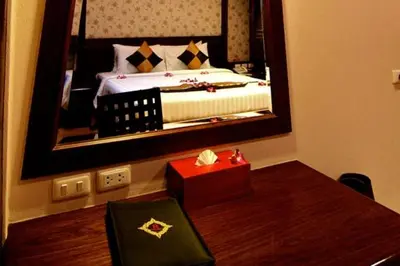 a bedroom with a bed in a mirror at Rayaburi Hotel, Patong in Patong Beach