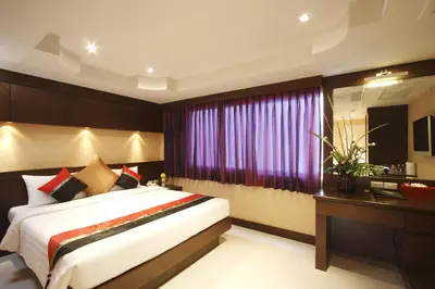 a bedroom with a large bed and a window at Rayaburi Hotel, Patong in Patong Beach