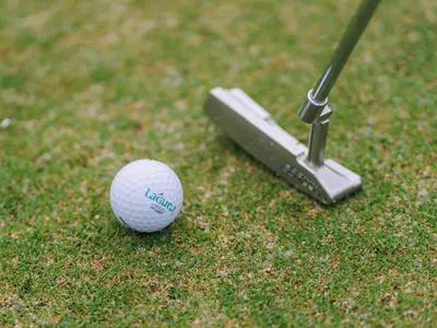 a golf ball and a putter on the grass at Dusit Thani Laguna Phuket in Bang Tao Beach