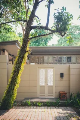 a building with a tree in front of it at SALA Phuket Mai Khao Beach Resort in Mai Khao Beach
