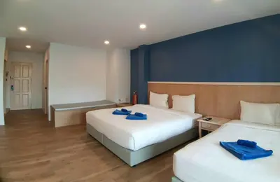 a bedroom with two beds with blue towels on them at Karon Living Room - SHA Plus in Karon Beach