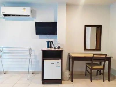 a room with a table and a desk with a tv at Karon Living Room - SHA Plus in Karon Beach