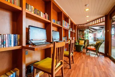 a library with a desk with a computer and chairs at Seaview Patong Hotel - SHA Plus in Patong Beach