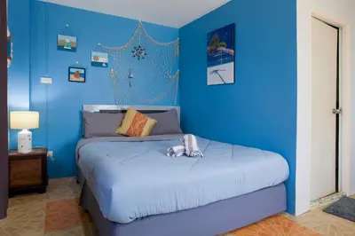 a blue bedroom with a bed with a dog on it at Klong Muang Sunset House in Klong Muang Beach