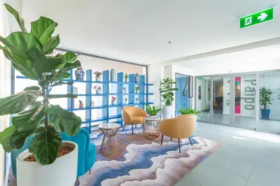 a large plant in a room with chairs and tables at Hotel Clover Patong Phuket - SHA Plus in Patong Beach