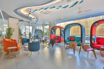 a waiting room with colorful chairs and tables at Hotel Clover Patong Phuket - SHA Plus in Patong Beach