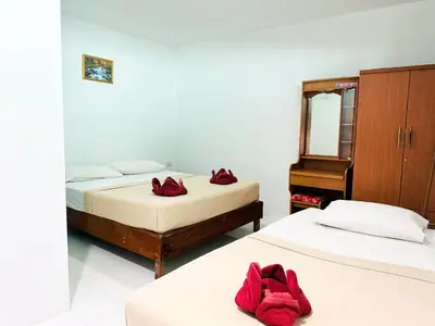 two beds in a room with red towels on them at Bang sit Guest House in Phi Phi Don