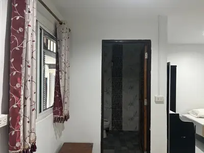 a hallway with a door and a window with curtains at Bang sit Guest House in Phi Phi Don