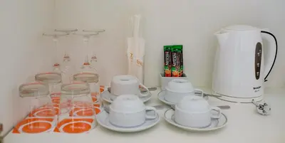 a counter with cups and plates and a blender at Tinidee Golf Resort Phuket in Kathu